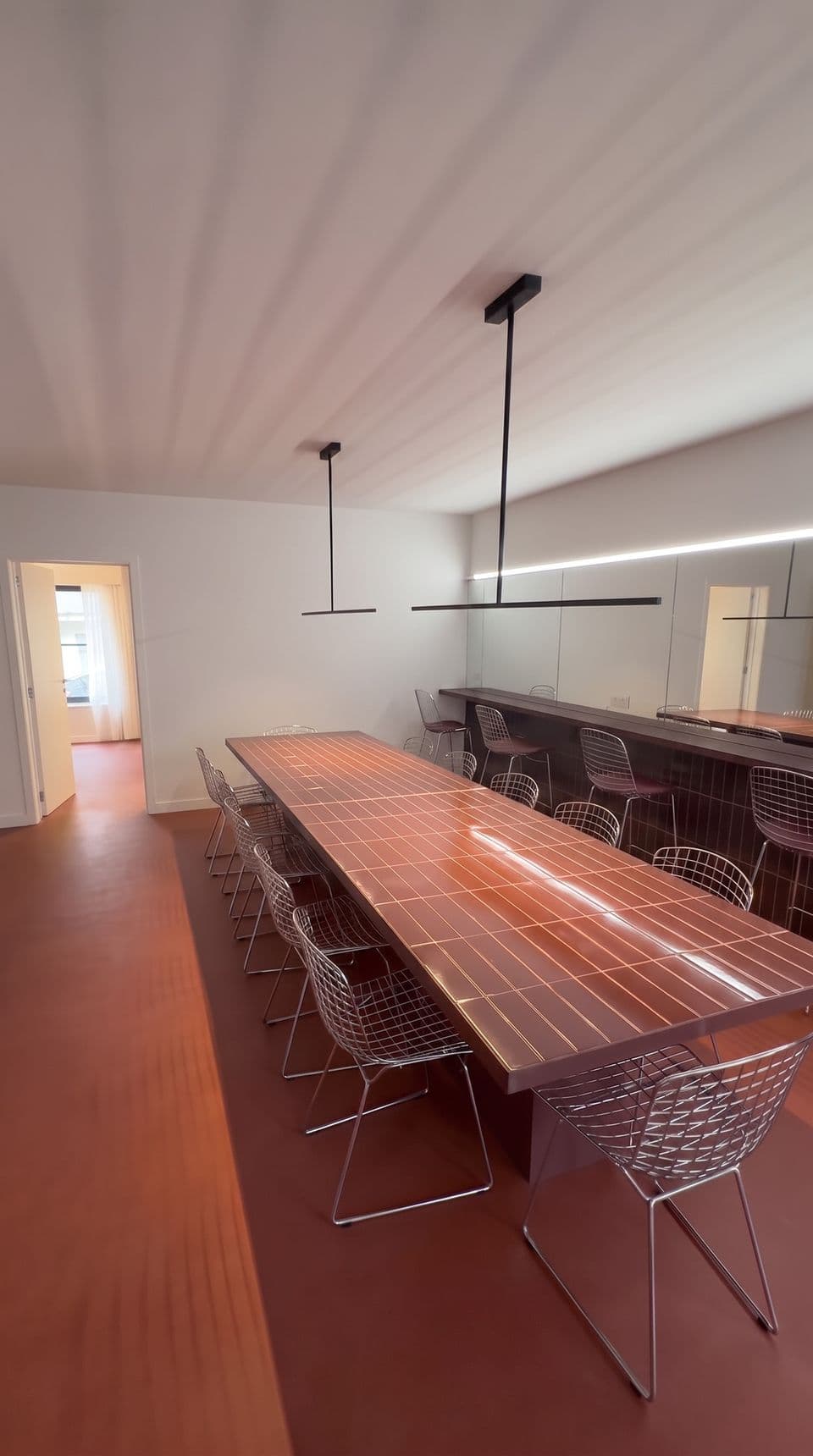 De lange tegeltafel met draadstoelen